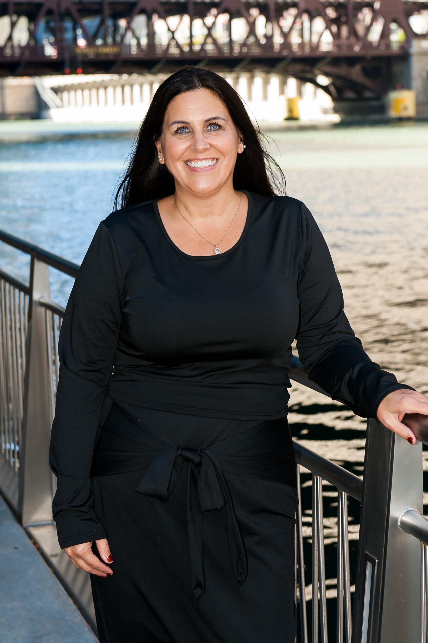 Portrait of attorney Kim Sanchez standing by the Chicago waterfront and smiling at the camera.